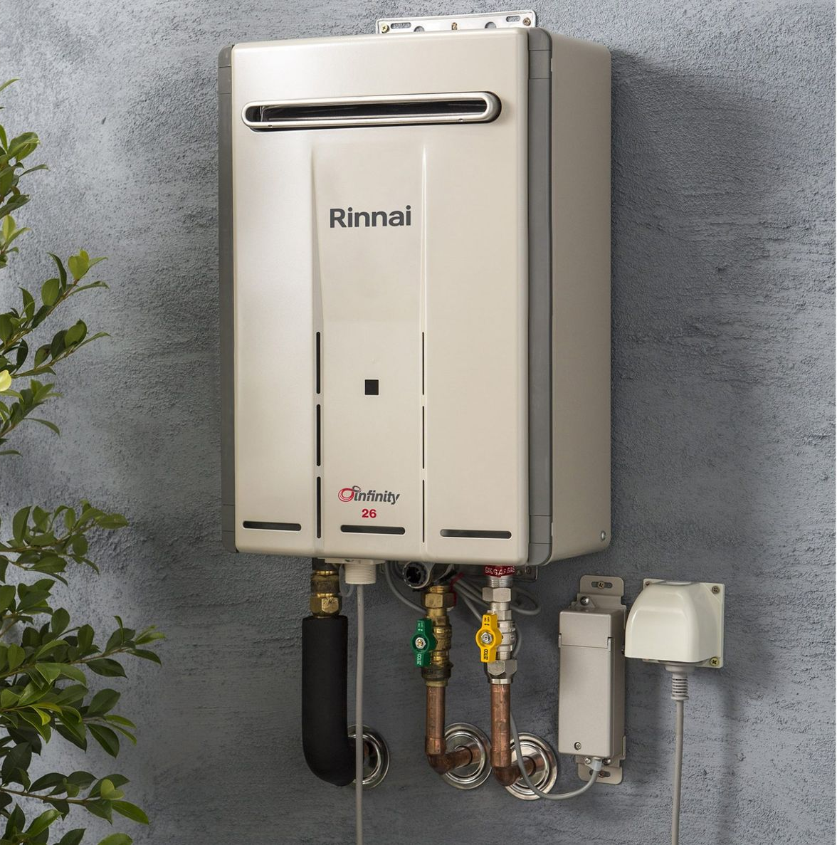 Wall-Mounted Rinnai Gas Water Heater with Pipes and Valves Against a Gray Wall — Forster Hotwater in Forster, NSW