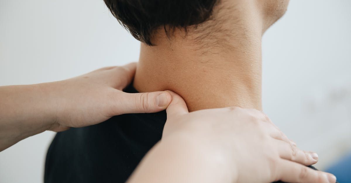 Hands massaging the neck and shoulder area of a person.