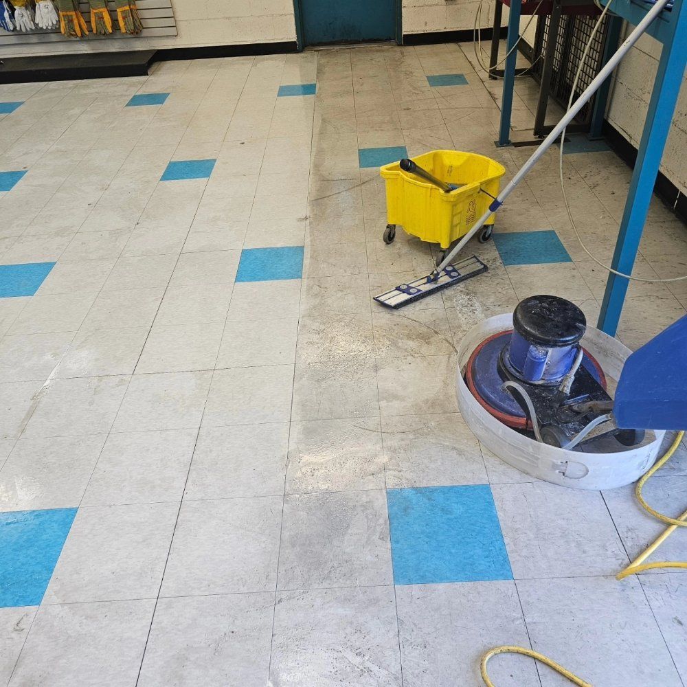 A woman is cleaning the floor with a mop in a kitchen.