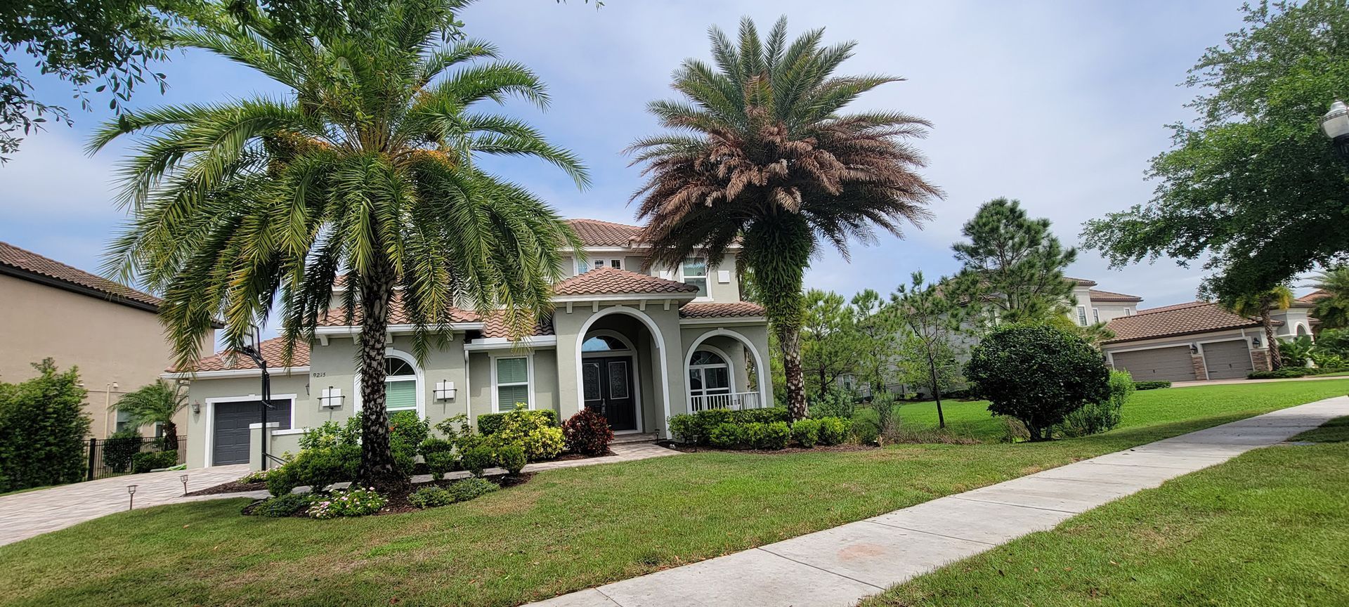 A large house with a palm tree in front of it.