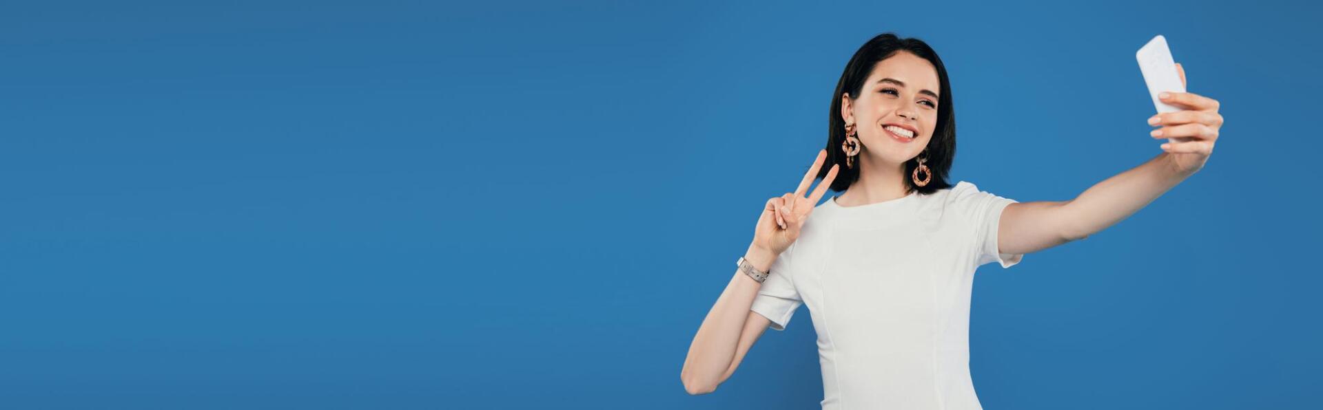 A woman is taking a selfie with her cell phone.