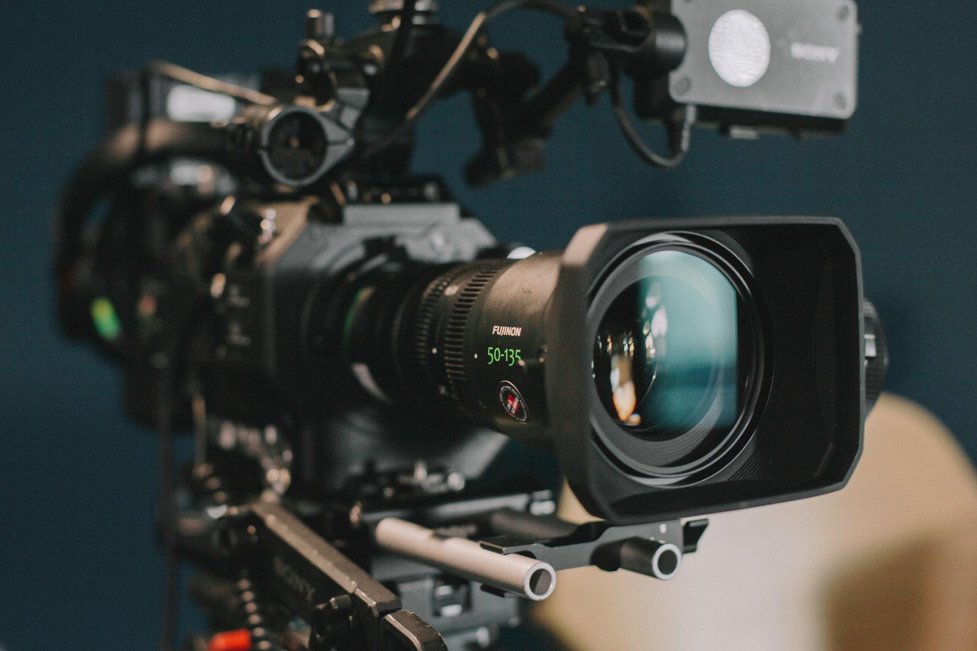 A close up of a video camera with a large lens.