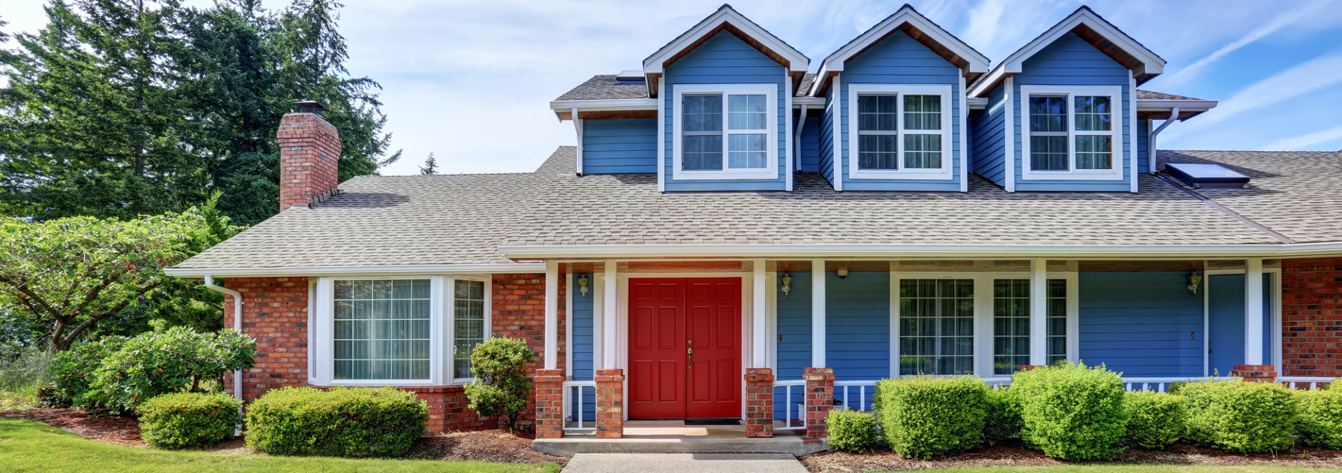 A blue house with a red door and a red porch.
