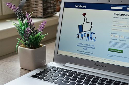 A laptop computer is open to a facebook page.
