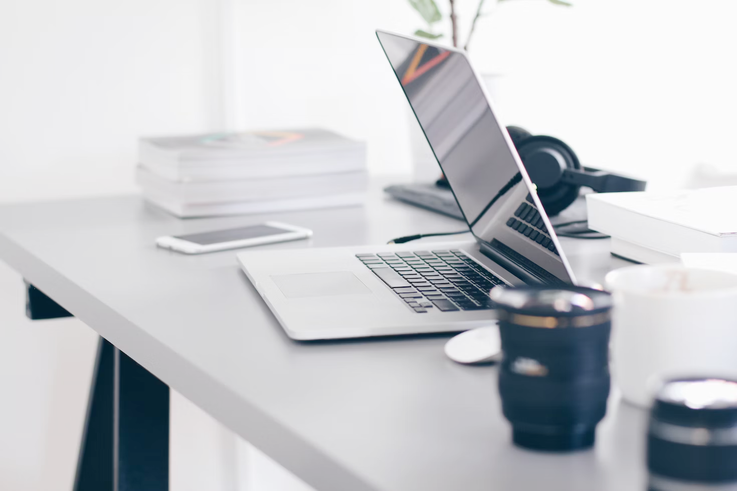 A laptop is open on a desk next to a cup of coffee