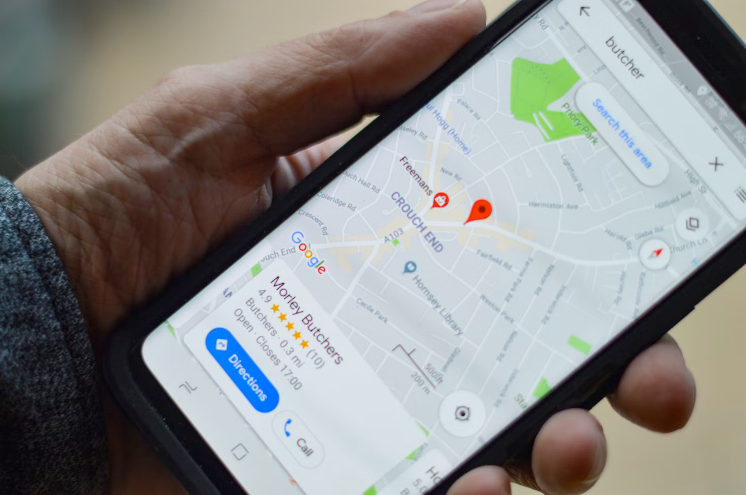 A person is holding a cell phone with a map on it.