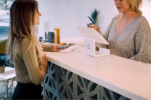A woman is sitting at a counter talking to another woman.
