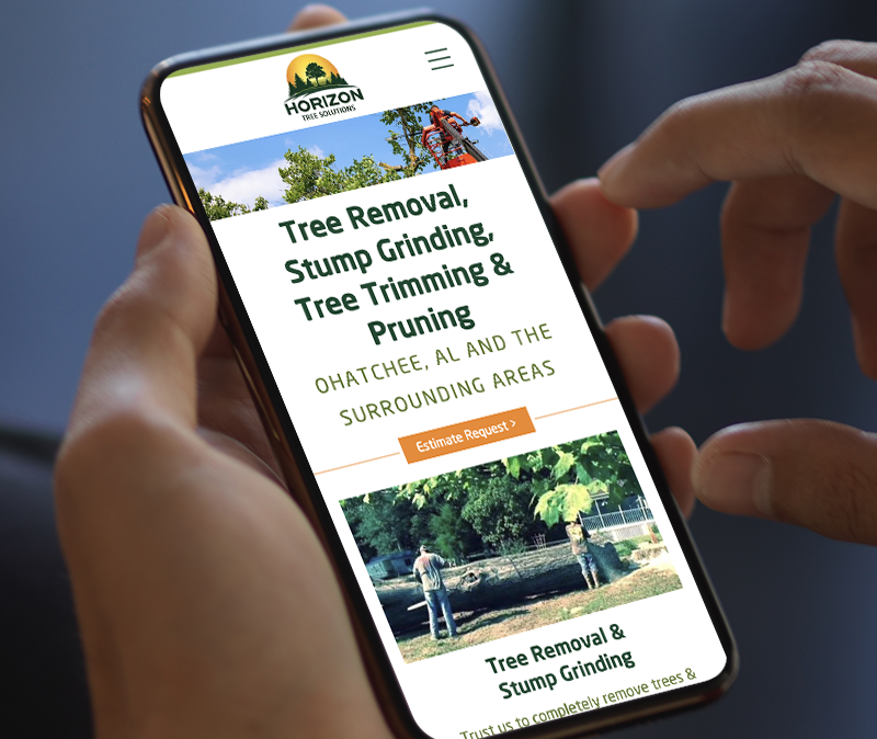 Hands holding a smartphone displaying a Horizon Tree Services website for tree removal and trimming in Ohatchee, AL.
