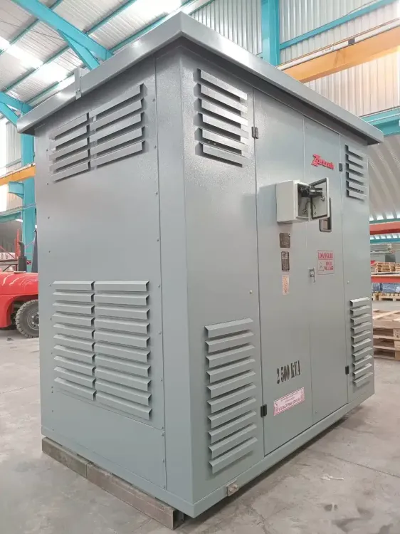 Gray industrial generator enclosure with vents and control box in a warehouse-like setting