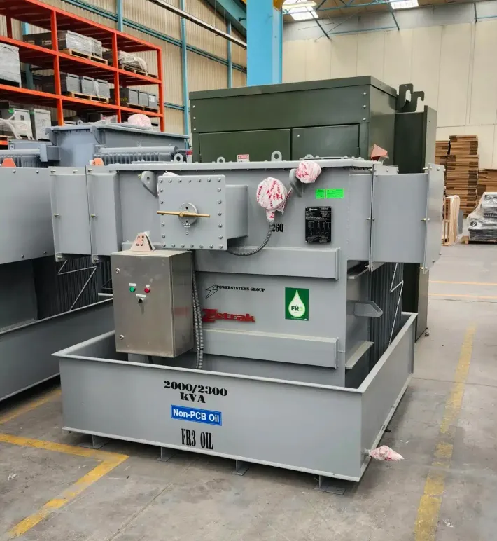 Gray industrial machine on a warehouse floor with gauges, controls, and a green hazard label.