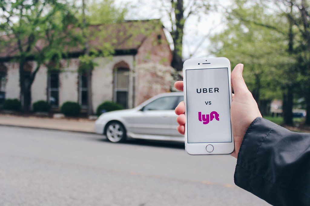 A person is holding a cell phone with a lyft app on it.