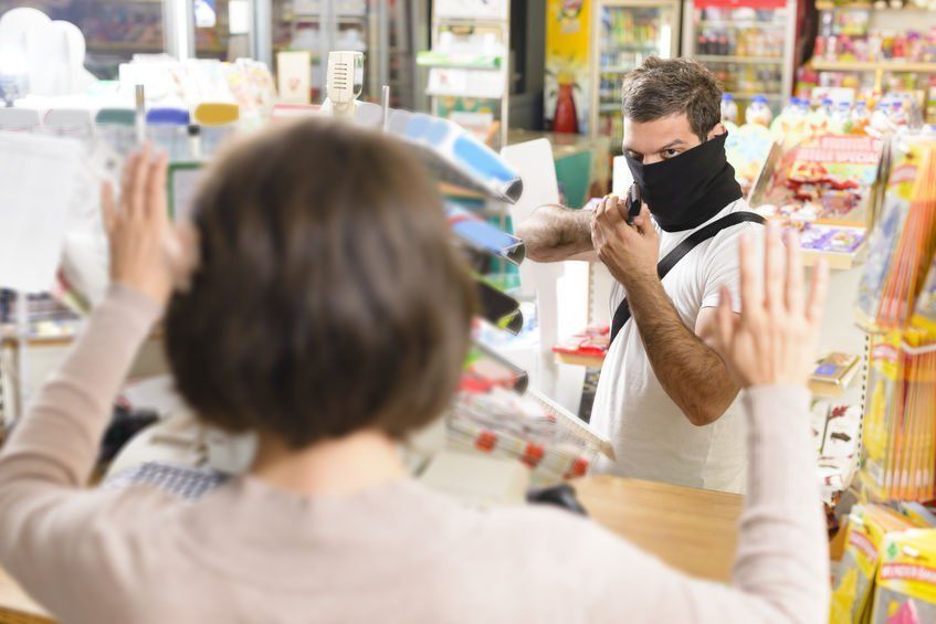 A man wearing a mask is standing next to a woman in a store.