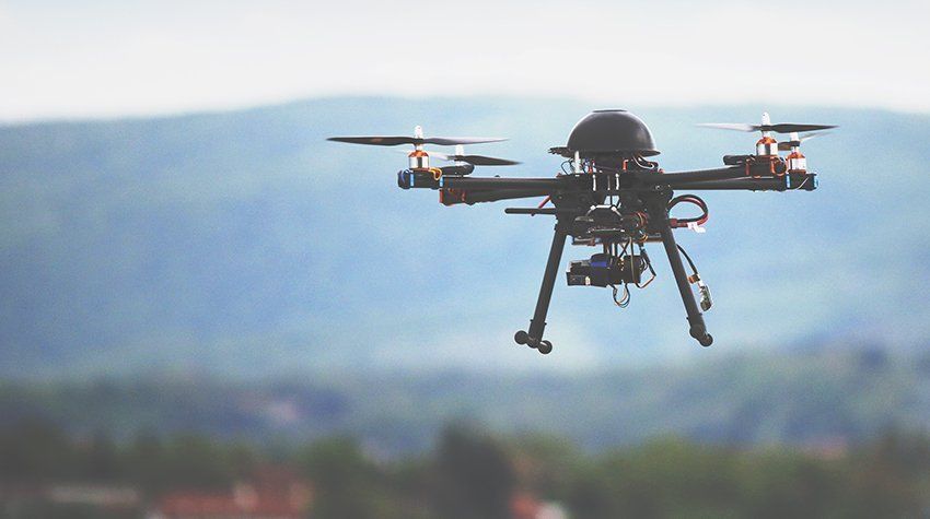 A drone is flying in the sky over a city.