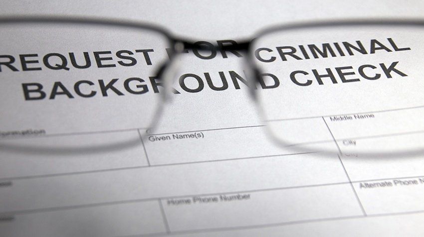 A pair of glasses sitting on top of a request for criminal background check form