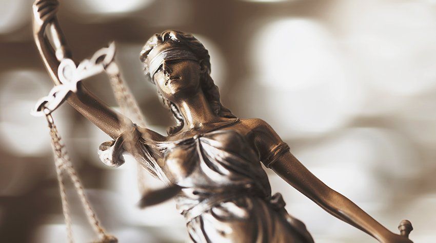 A statue of a blindfolded woman holding a scale of justice.