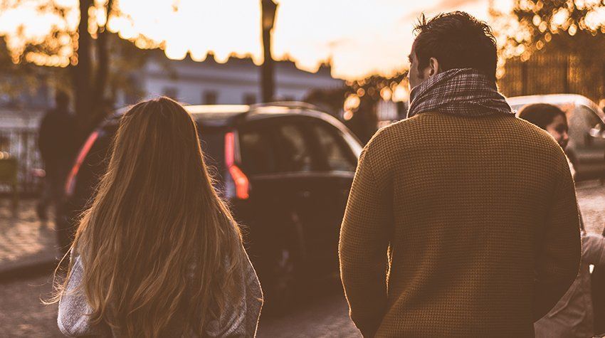 A man and a woman are walking down a street.
