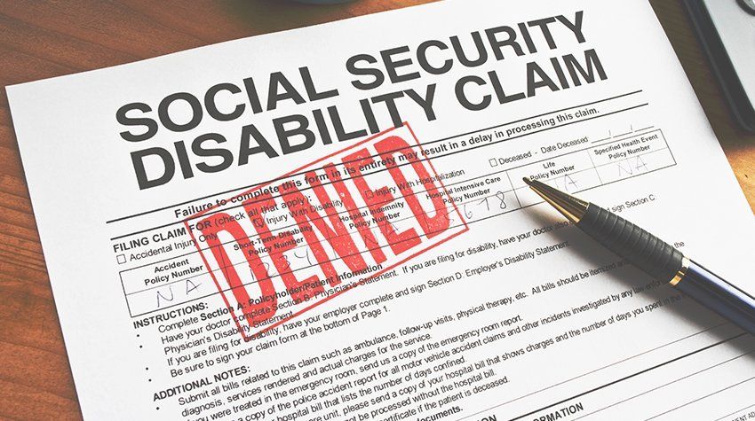A pen is sitting on top of a social security disability claim form.