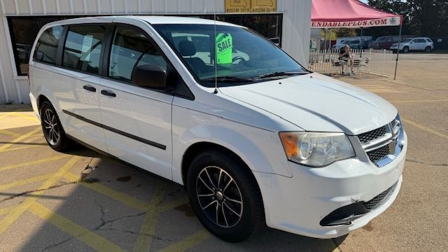 White minivan parked outside a building on a sunny day | Dependable Automotive