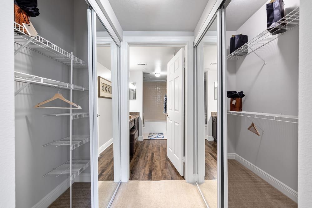 a walk-in closet with sliding glass doors and shelves at Marquis on Pin Oak in Houston, TX.