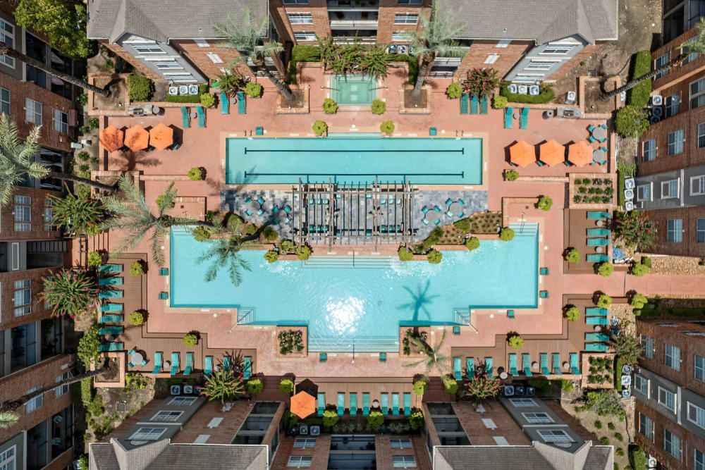 an aerial view of a large swimming pool surrounded by buildings at Marquis on Pin Oak in Houston, TX.