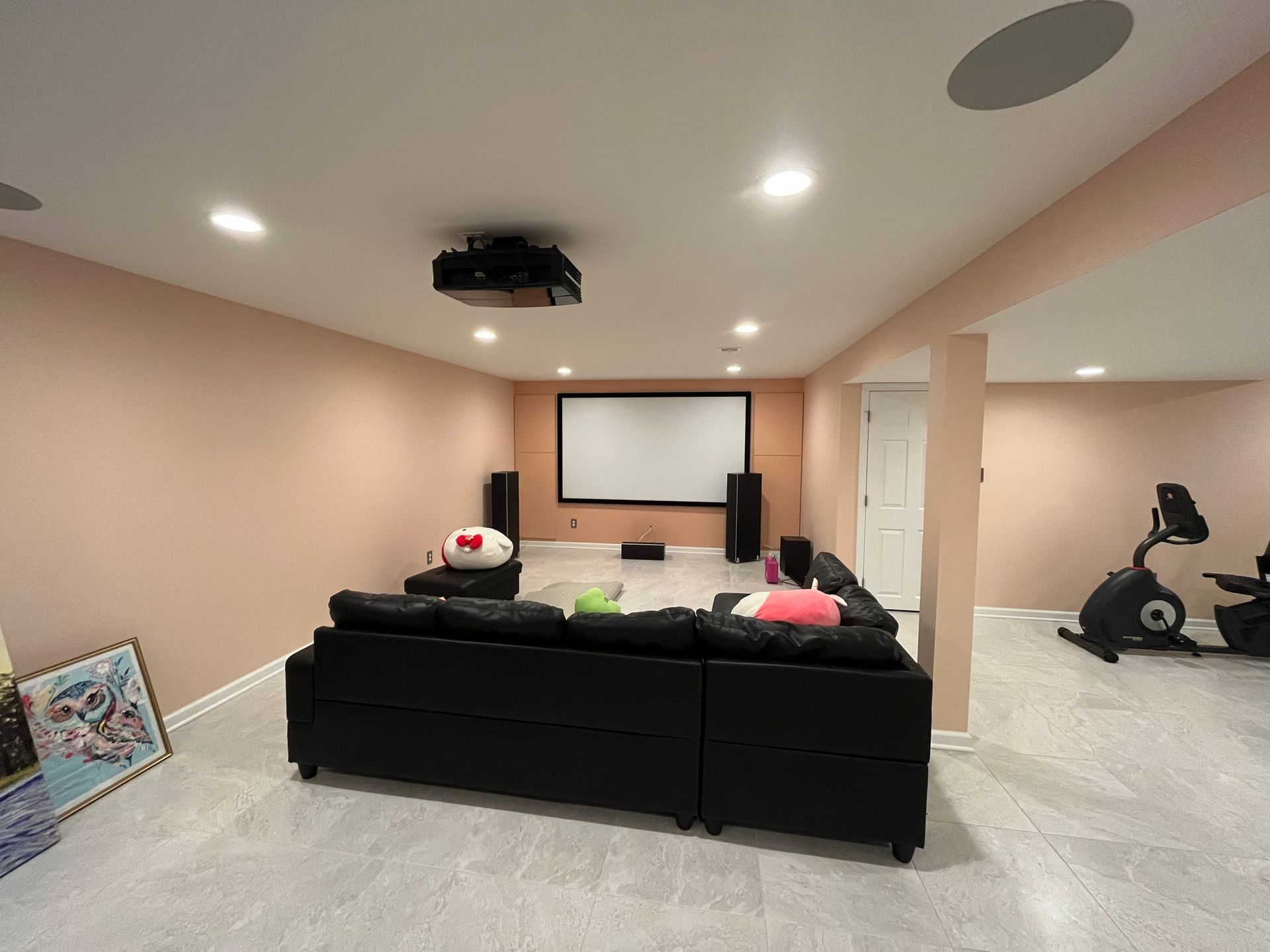 A basement with a projector screen and a couch
