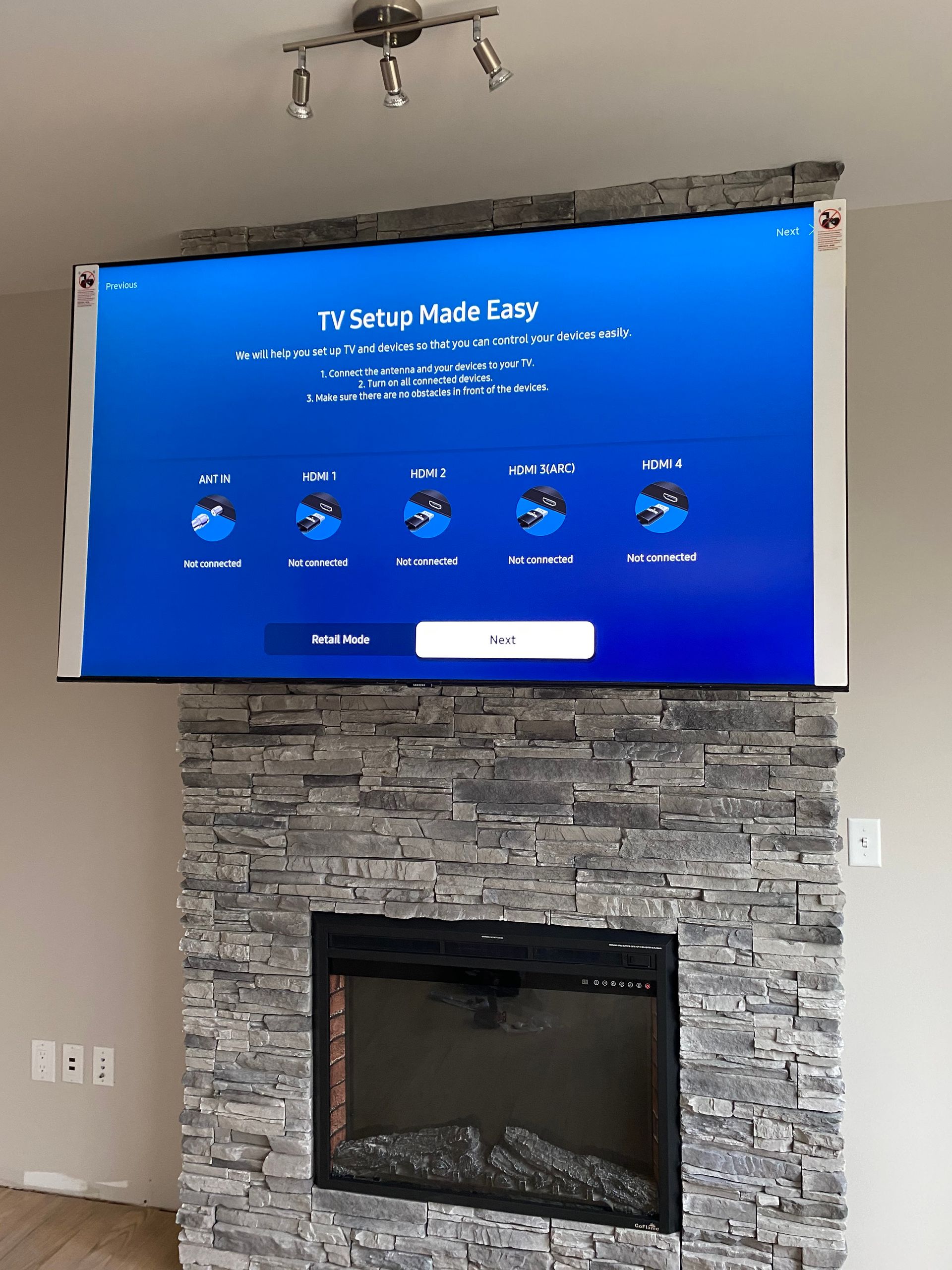 A flat screen tv is mounted above a fireplace