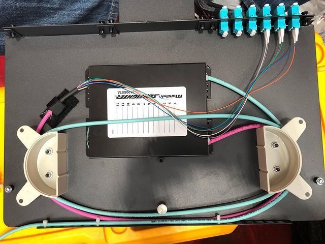 A bunch of wires are connected to a box that says ' optical ' on it