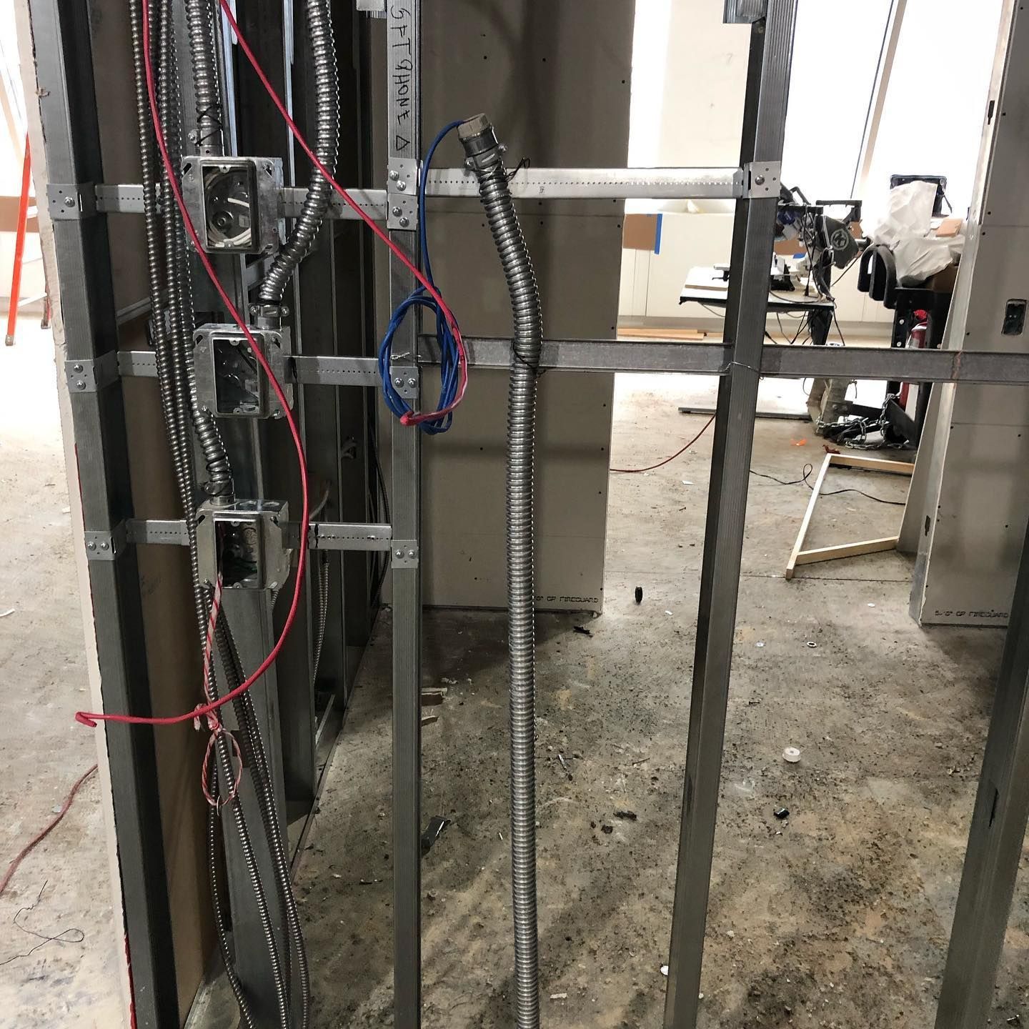 A bunch of wires are hanging from a metal frame in a room.