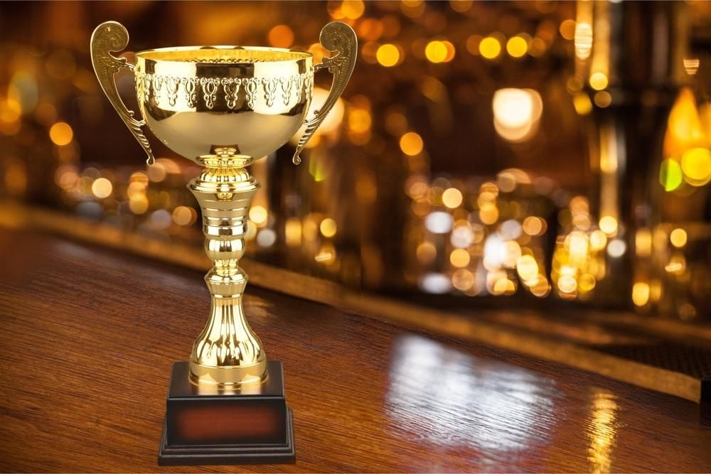 A Gold Trophy is Sitting on a Wooden Table — Nightcliff Plumbing & Gas In Coconut Grove, NT