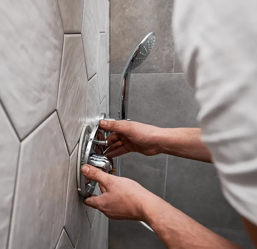 A Plumber Fitting a Tap to a Tiled Wall— Nightcliff Plumbing & Gas In Coconut Grove, NT
