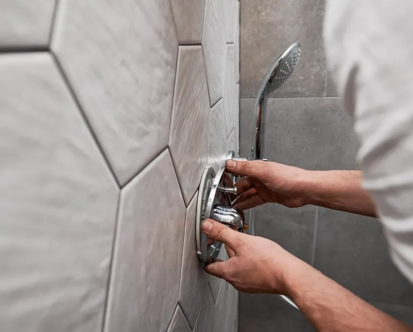 A Plumber Installing A Mixer Tap On A Shower Wall — Nightcliff Plumbing & Gas In Berry Springs, NT