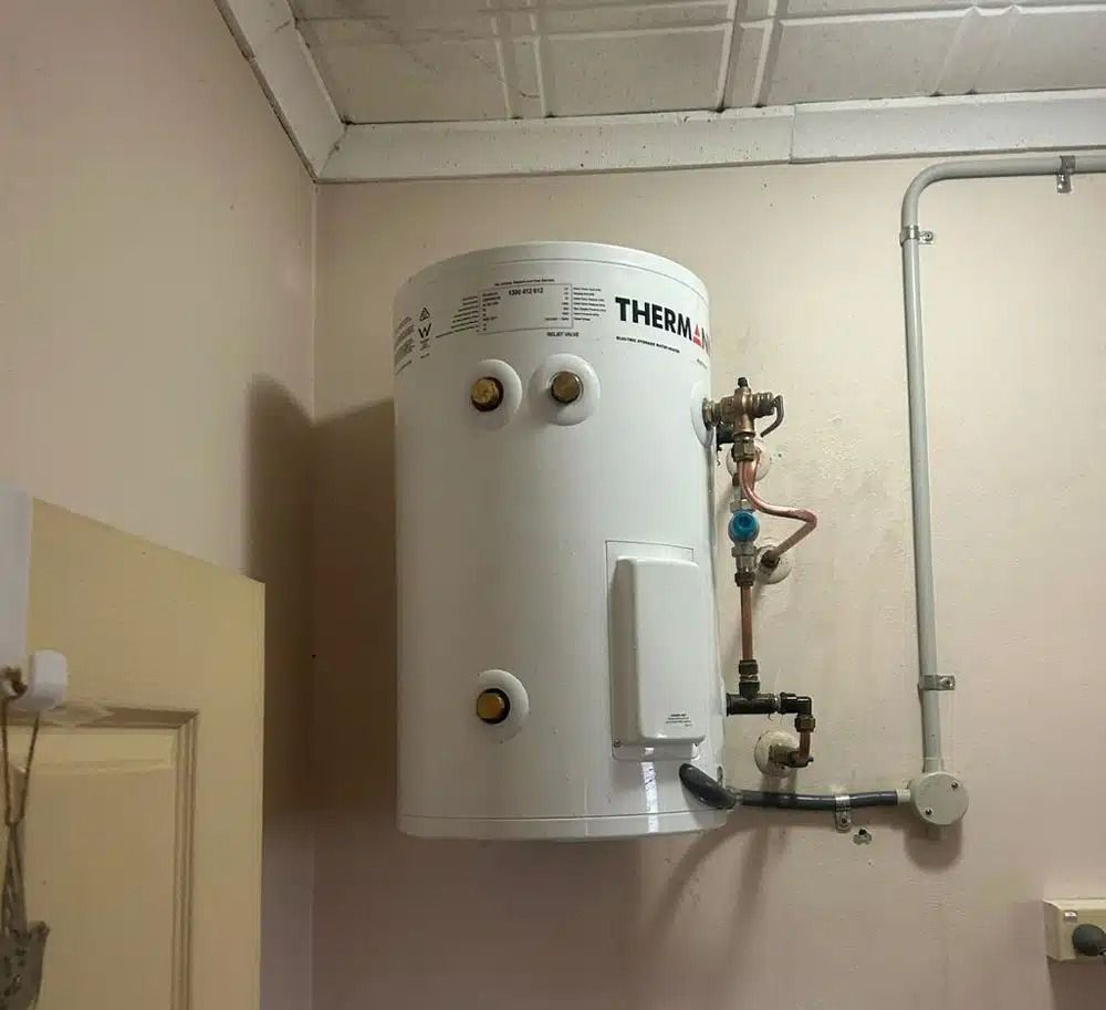 A White Water Heater is Hanging on a Wall — Nightcliff Plumbing & Gas In Coconut Grove, NT