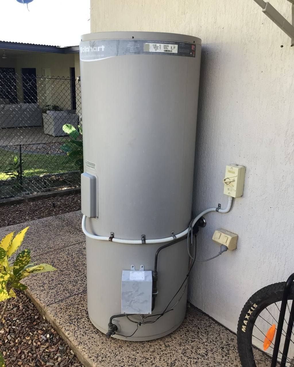 A Large Gray Water Heater is Sitting on the Side of a Building — Nightcliff Plumbing & Gas In Stuart Park, NT
