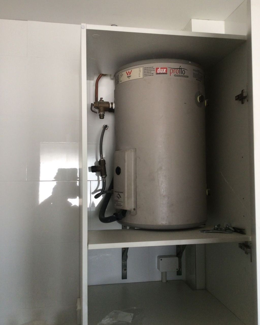 A Water Heater is Sitting Inside of a Cabinet — Nightcliff Plumbing & Gas In Parap, NT
