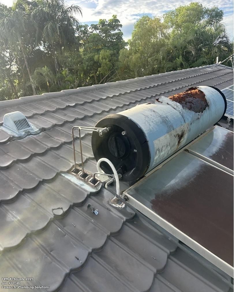 A Water Heater is Sitting on Top of a Roof Next to a Solar Panel — Nightcliff Plumbing & Gas In Coconut Grove, NT