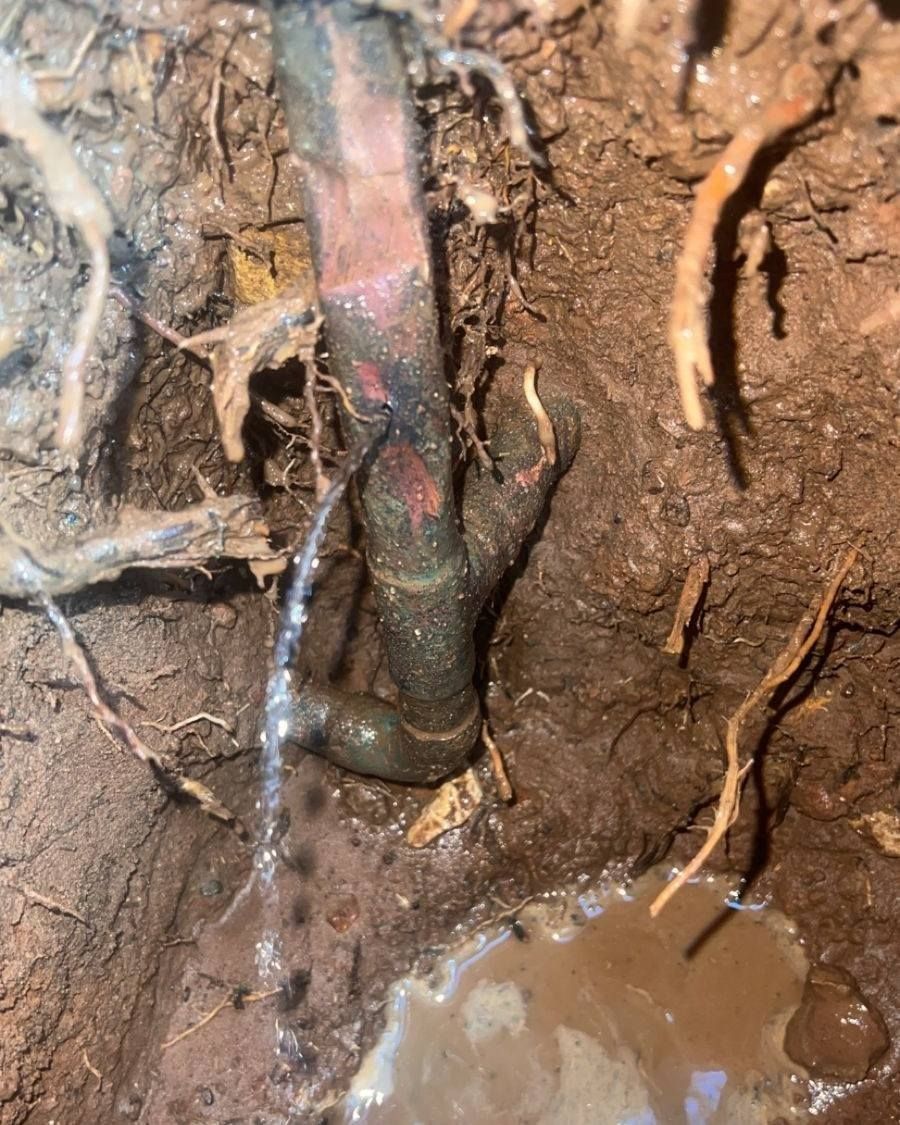 A Close Up of a Pipe in the Ground With Water Coming Out of It — Nightcliff Plumbing & Gas In Fannie Bay, NT