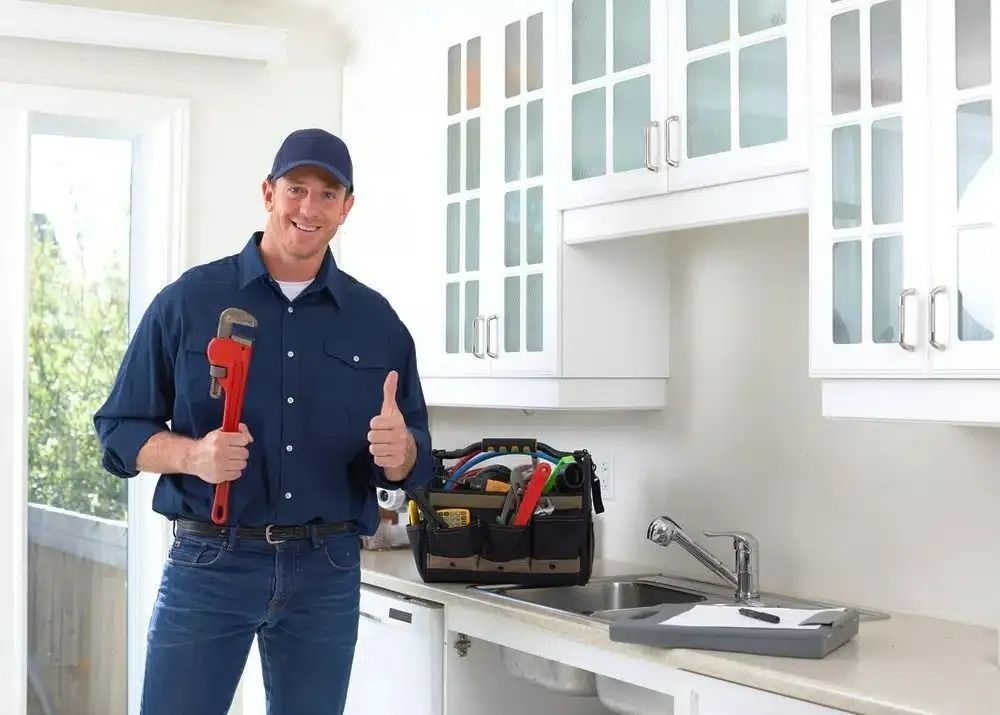 Plumber is Standing in a Kitchen Holding a Wrench and — Nightcliff Plumbing & Gas In Coconut Grove, NT
