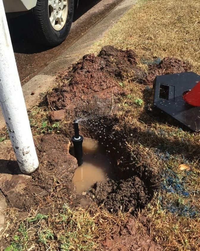 A Sprinkler is Being Installed in a Hole in the Ground — Nightcliff Plumbing & Gas In Coconut Grove, NT
