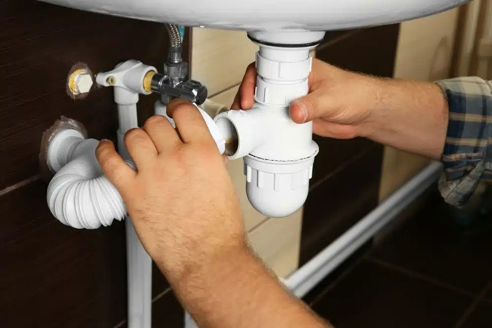 A Plumber Replacing A Leaking Pipe Under A Sink — Nightcliff Plumbing & Gas In Berry Springs, NT