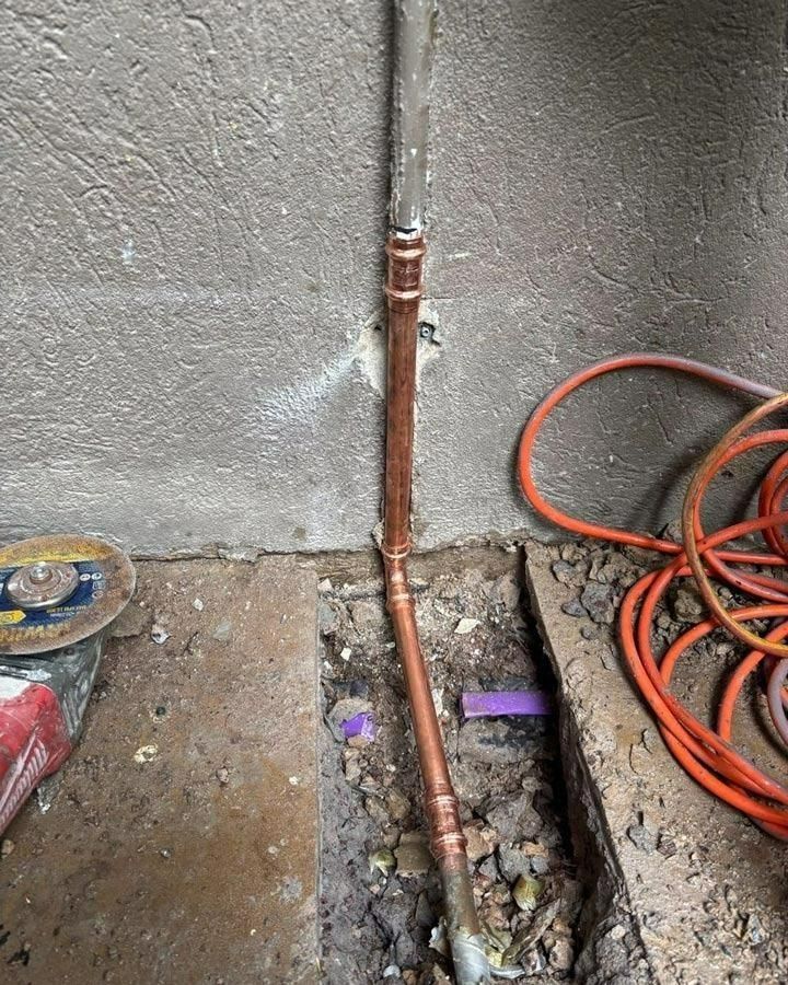 A Copper Pipe is Being Installed in a Hole — Nightcliff Plumbing & Gas In Coconut Grove, NT