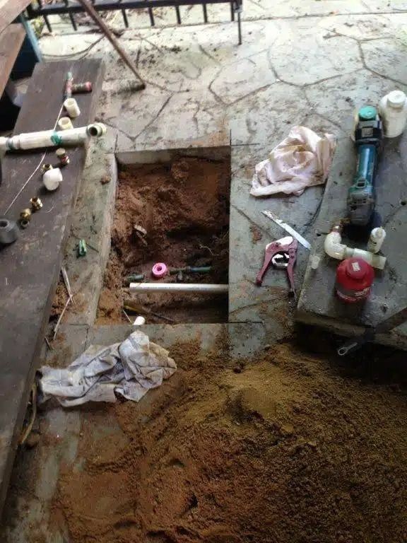 A Hole in the Ground With Pipes and Tools in It — Nightcliff Plumbing & Gas In Coconut Grove, NT
