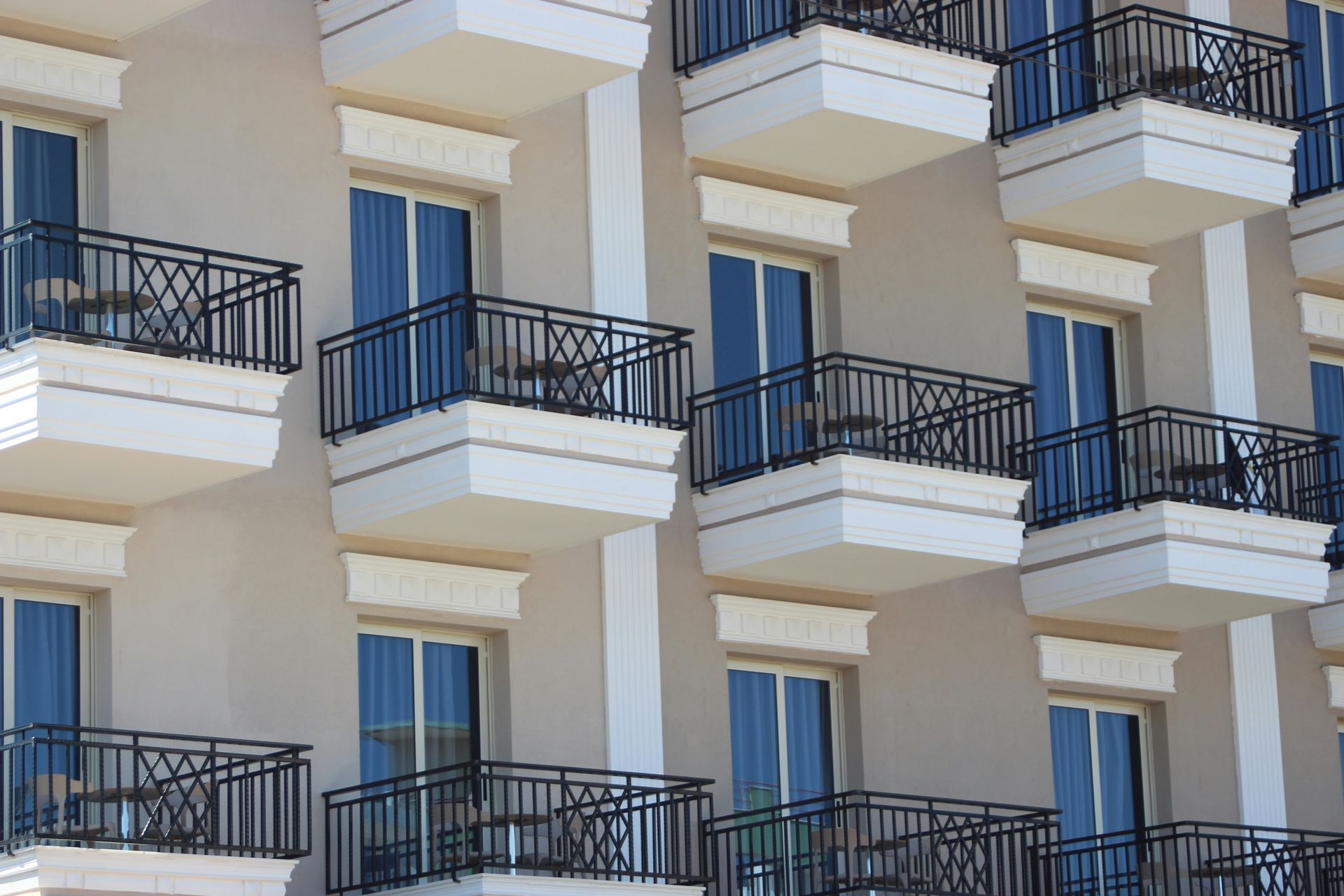 White apartment building with blue balcony railings and windows