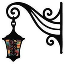 Ornate black wall lantern with colorful glass, hanging from a decorative wrought-iron bracket