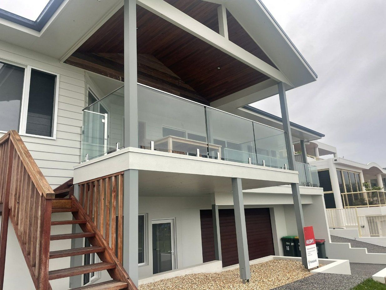 A White House with A Balcony and Stairs Leading up To It — Topline Aluminium Forster Pty Ltd in Forster, NSW