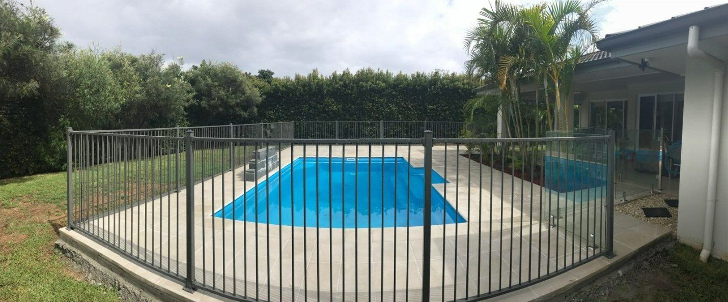 A Large Swimming Pool Surrounded by A Metal Fence — Topline Aluminium Forster Pty Ltd in Forster, NSW