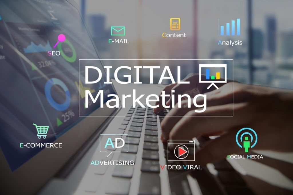 A person is typing on a laptop with the words digital marketing in the background.