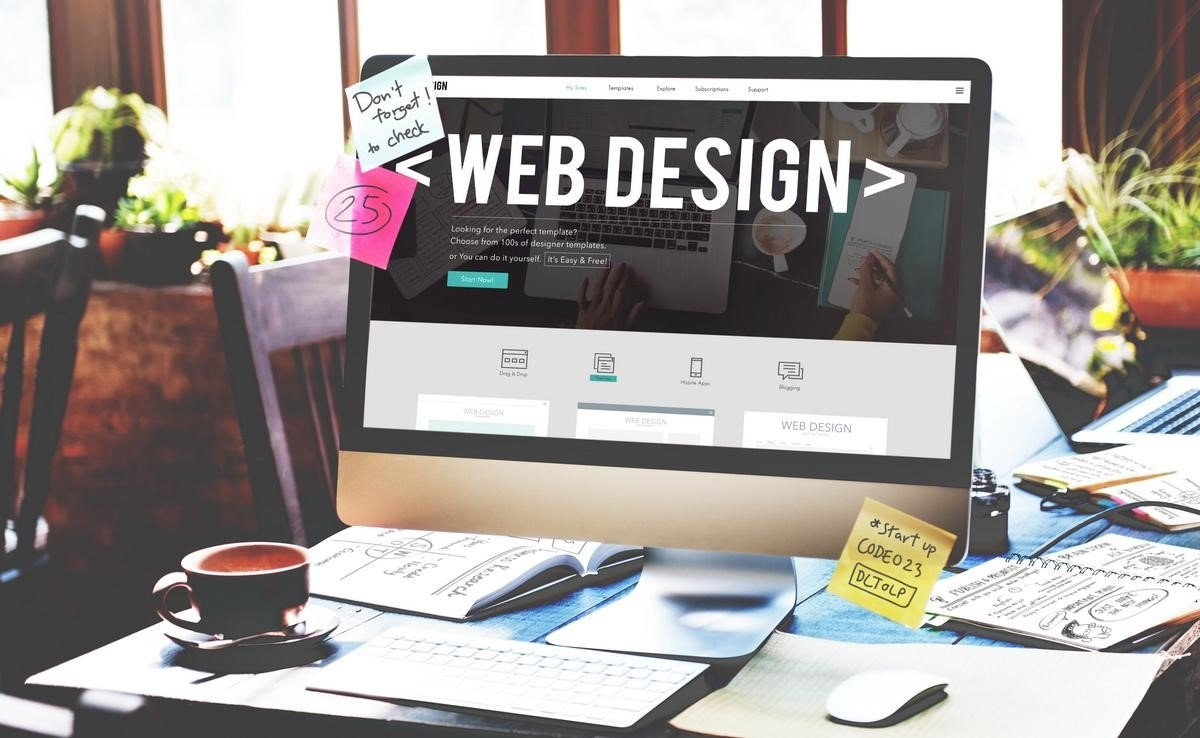 A computer is sitting on a desk with a web design website on the screen.