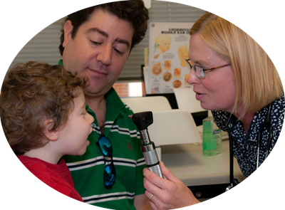 A man and a woman are looking at a child 's eyes