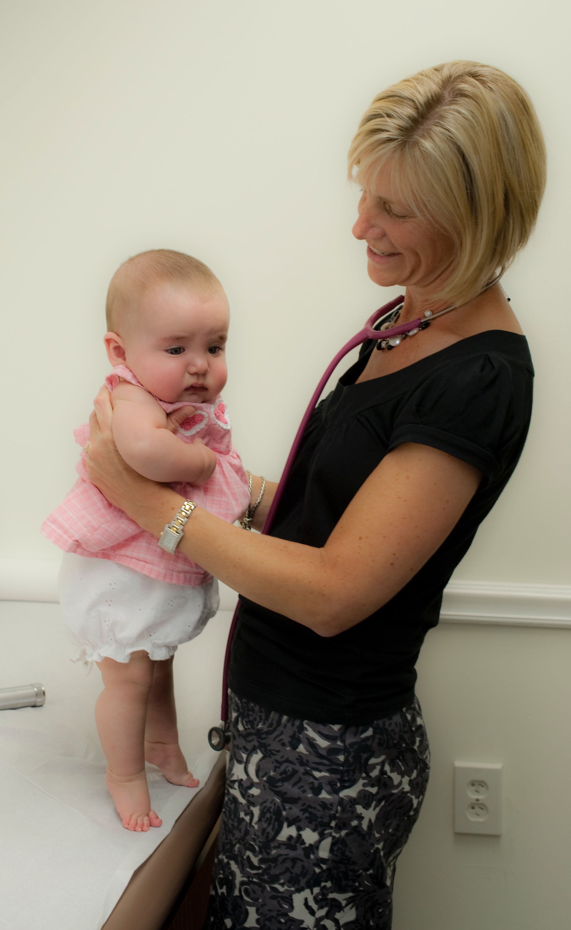 A pediatrician is examining a baby