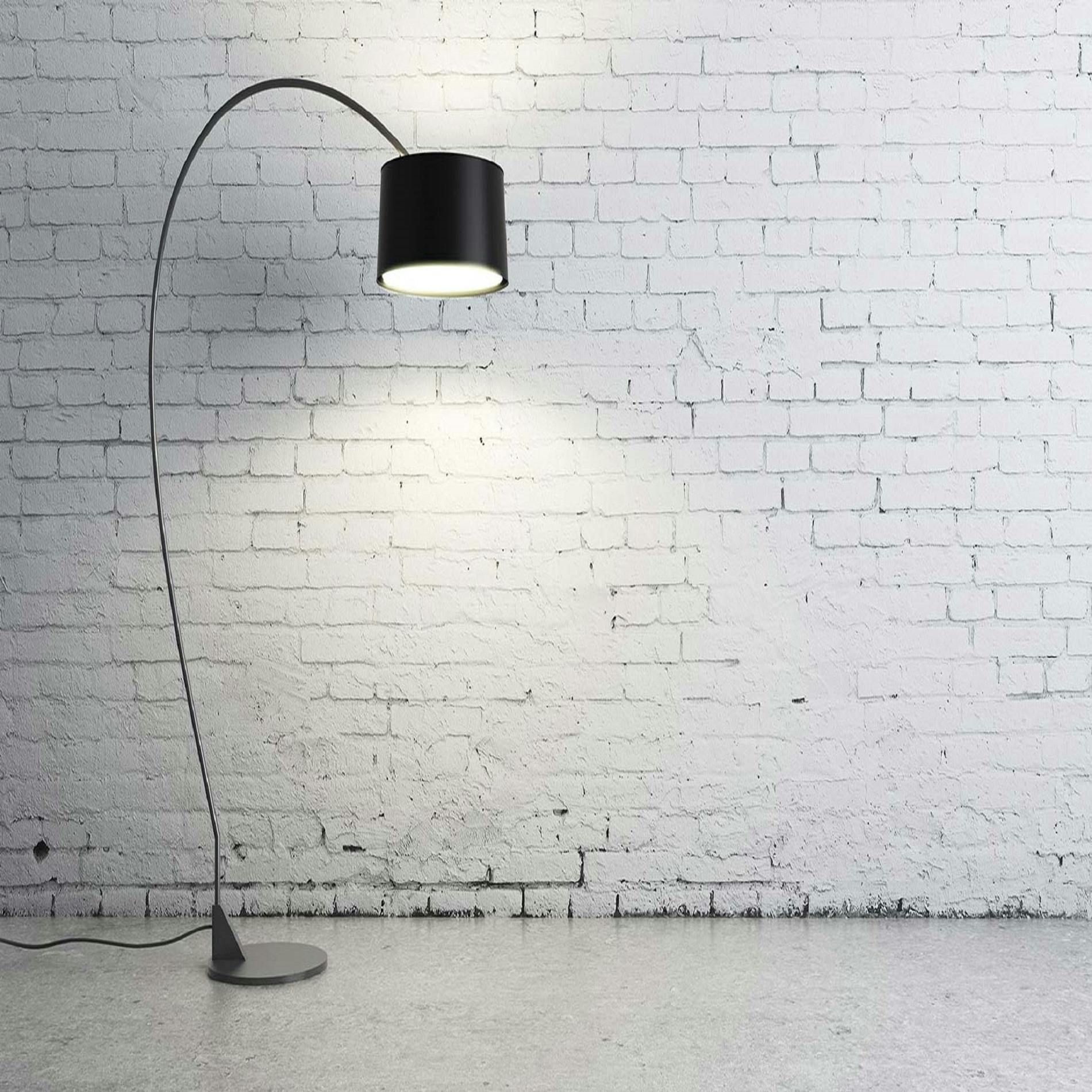 A lamp is lit up in front of a white brick wall